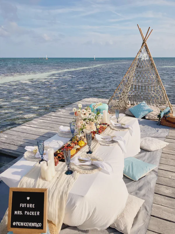 Elegante picnic en muelle con cristalería azul