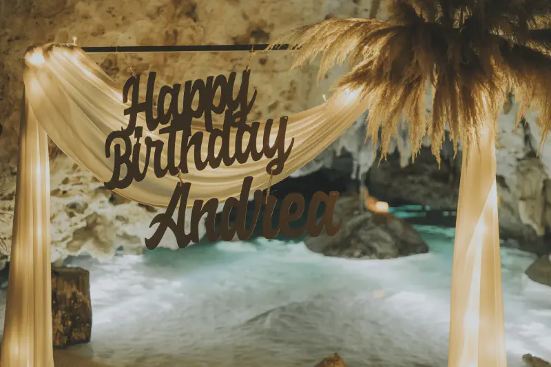 &lsquo;Happy Birthday&rsquo; sign hanging from an illuminated arch inside a cave