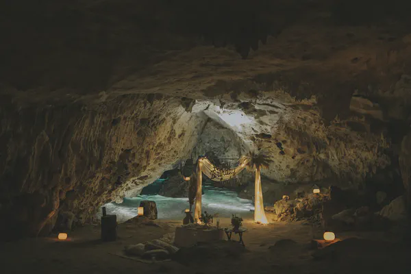 Vista gran angular de una cueva de cenote mostrando un montaje elaborado con iluminación suave y piscina iluminada