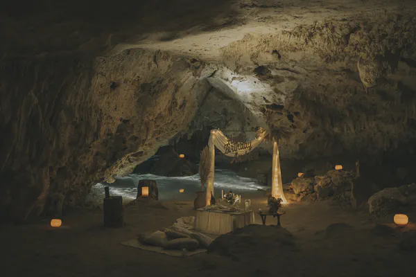 Escena de cena romántica bellamente arreglada en una cueva, con iluminación suave de linternas y velas