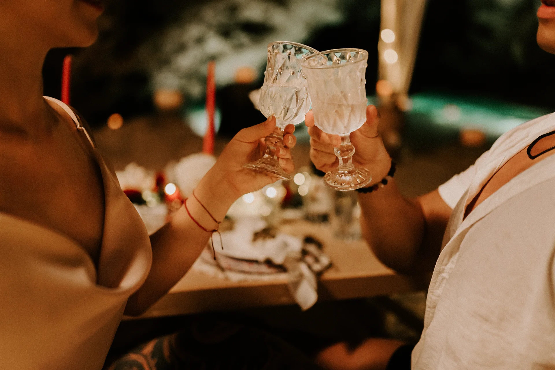 Couple toasting with crystal glasses in a romantic cave setting