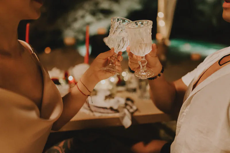 Pareja brindando con copas de cristal en un ambiente romántico de cueva
