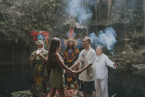 Intimate moment during a traditional Mayan vow renewal ceremony in a mystical cenote setting