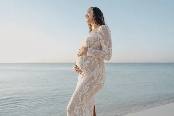 Expectant mother during a beach maternity photoshoot at sunrise in Riviera Maya