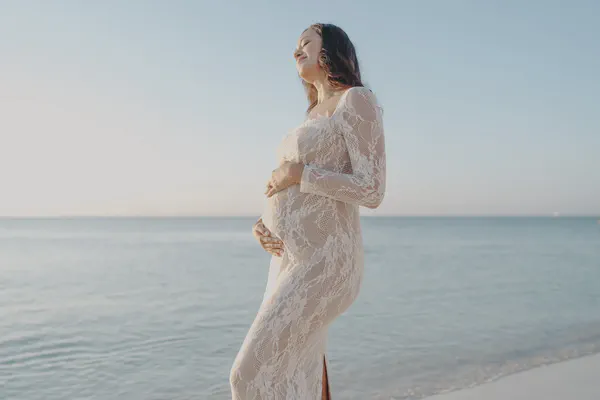 Expectant mother during a beach maternity photoshoot at sunrise in Riviera Maya