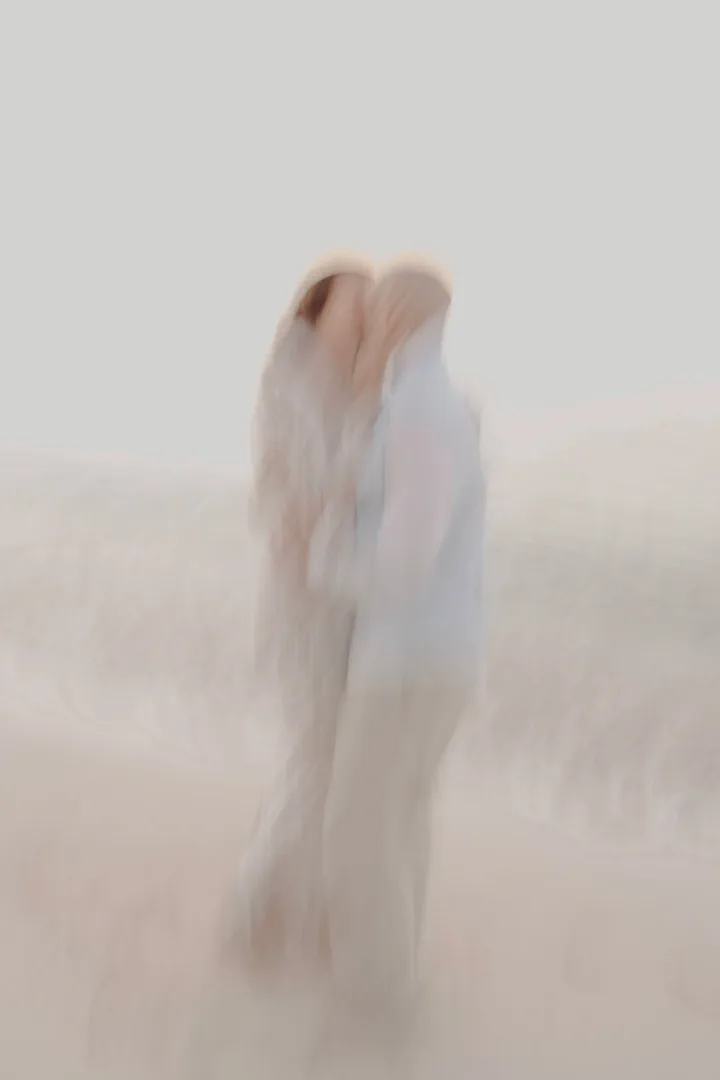 Soft-focus portrait of a couple embracing at the water’s edge