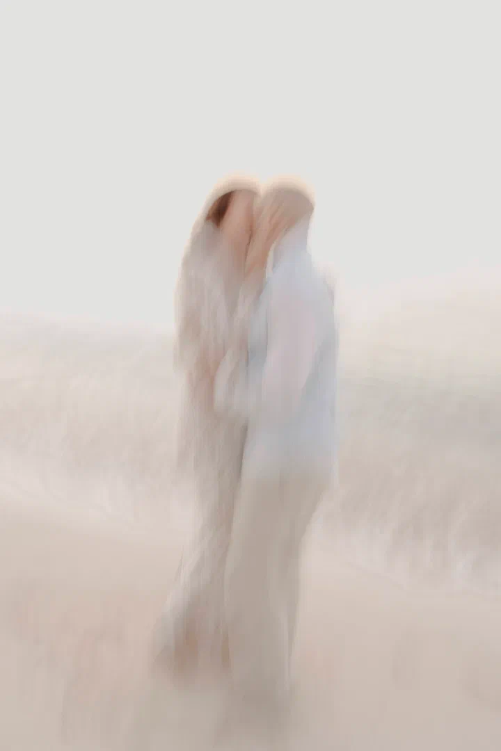 Soft-focus portrait of a couple embracing at the water’s edge