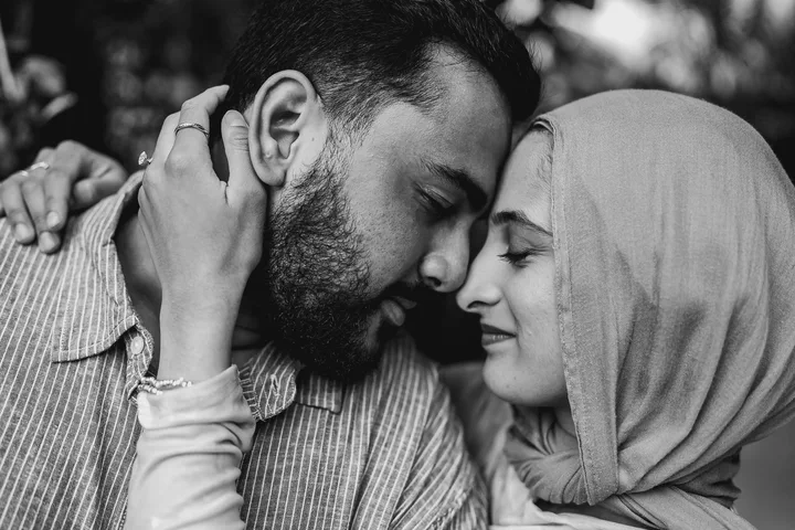 Black-and-white close-up of a couple touching foreheads in an embrace