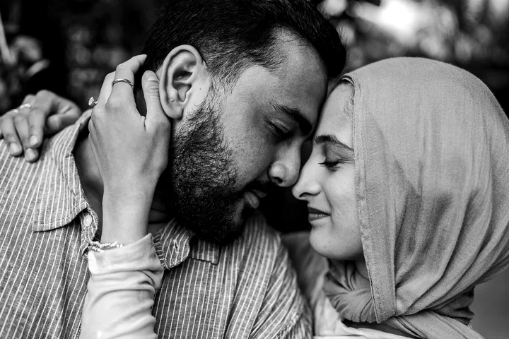 Black-and-white close-up of a couple touching foreheads in an embrace