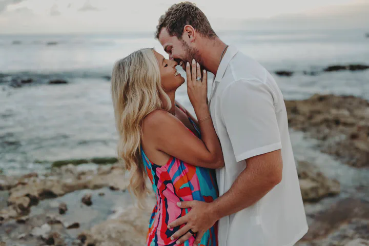 Couple embracing beside the sea, with the woman in a colorful dress